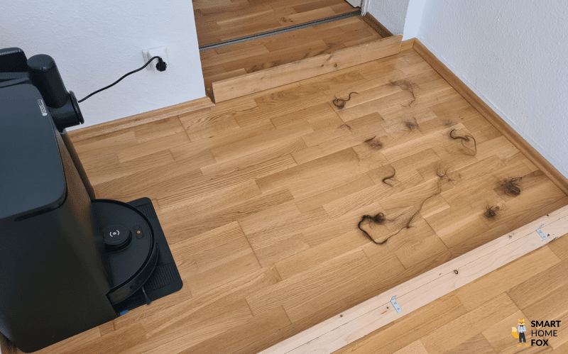 Haare werden im Testareal verteilt und der ECOVACS DEEBOT T30S COMBO COMPLETE darf diese aufsaugen.